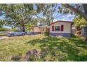 Single-story home featuring a well-maintained lawn, garage and light colored exterior at 9029 109Th Ave, Seminole, FL 33777