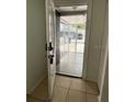 Home's entryway featuring tile flooring, screened-in porch, and a white front door at 9106 Telford Ct, Tampa, FL 33615
