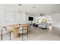 Open floor plan with modern dining area, comfortable living room, and sleek polished concrete floors at 9485 Treasure Ne Ln, St Petersburg, FL 33702