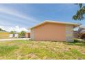 Exterior of a peach colored house with neutral brick features and green grass at 9591 Commodore Dr, Seminole, FL 33776