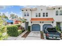 A two story home with terracotta tile roof, blue garages and truck parked in the driveway at 102 S Moody Ave # 1, Tampa, FL 33609