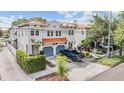A two story home with terracotta tile roof, blue garages and lush landscaping at 102 S Moody Ave # 1, Tampa, FL 33609