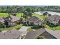 Aerial view of a home with well-maintained landscaping, tile roof, near a pond and golf course at 1111 Jasmine Creek Ct, Sun City Center, FL 33573