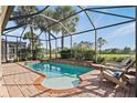 Relaxing screened-in pool area with a brick surround, seating, and lush landscaping creating a private oasis at 1111 Jasmine Creek Ct, Sun City Center, FL 33573