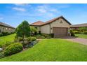 Beautiful home featuring a well-maintained lawn, lush landscaping, and a two-car garage at 11354 Callisia Dr, Odessa, FL 33556