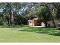Exterior view of garage with car inside on a beautiful lawn with an American flag in the yard at 12929 Sugar Creek Blvd, Hudson, FL 34669