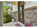 Inviting entryway features a glass-paneled door, stone accents, and potted plants, enhancing curb appeal at 13311 Dorado Shores Ave, Riverview, FL 33579