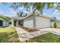 Charming single-Gathering home featuring a two-car garage, sidewalk and well-maintained front lawn at 13814 Harvestwood Ln, Riverview, FL 33569