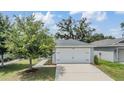 Charming single-Gathering home featuring a two-car garage and well-maintained front lawn at 13814 Harvestwood Ln, Riverview, FL 33569