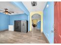 Bright foyer featuring wood-look tile flooring, blue accent walls, and an adjacent living space at 14135 Arbor Pines Dr, Riverview, FL 33579