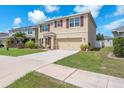 Charming home with a two-car garage, complemented by lush green grass and well-kept landscaping at 14135 Arbor Pines Dr, Riverview, FL 33579