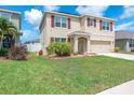 Inviting two-story home boasts a well-maintained lawn and vibrant landscaping, perfect for curb appeal at 14135 Arbor Pines Dr, Riverview, FL 33579