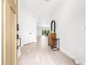 Bright entryway with wood-look tile flooring, white walls, and a view into the living area at 18036 Java Isle Dr, Tampa, FL 33647