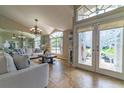 Bright and airy living room featuring tile floors, a chandelier, and ornate glass french doors at 18504 Country Crest Pl, Tampa, FL 33647