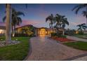 Inviting single story home featuring a tile roof, double door entryway and a brick driveway surrounded by palm trees at 1931 Kentucky Ne Ave, St Petersburg, FL 33703