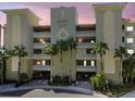 Majestic Point condos exterior featuring a neutral facade, tropical landscaping, and secure gated entrances at 200 Skiff Pt # 202, Clearwater Beach, FL 33767