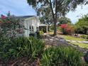 Lush backyard with mature landscaping, stone path, and screened patio at 20938 Sunsweet Ct, Land O Lakes, FL 34637