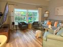 Inviting living room with hardwood floors, neutral decor, and large window at 20938 Sunsweet Ct, Land O Lakes, FL 34637