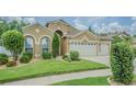 Inviting two-story home with well-maintained lawn and garden beds, and an attached three-car garage at 2124 Rensselaer Dr, Wesley Chapel, FL 33543
