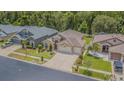 Charming single-Gathering home with an attached three-car garage, a landscaped front yard, and mature trees at 2124 Rensselaer Dr, Wesley Chapel, FL 33543