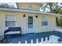 Close up front view of the porch with a love seat and an inviting front door with a wreath at 284 North St, Palm Harbor, FL 34683