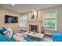 Cozy living room boasting a brick fireplace, bright windows, and modern TV at 284 North St, Palm Harbor, FL 34683