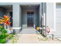 Inviting front entrance with a black door and decorative landscaping at 2925 Evergreen Elm Pass, Wesley Chapel, FL 33543