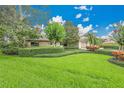 Well-maintained front yard with lush green grass and mature trees at 3207 Hilltop Ln, Largo, FL 33770