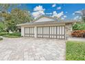 Spacious garage with decorative doors and a paver driveway at 3207 Hilltop Ln, Largo, FL 33770