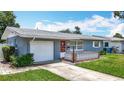 A cozy single-story home with an attached garage and a welcoming front patio with brick accents at 3271 36Th N St, St Petersburg, FL 33713