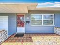 Inviting front porch featuring a red door, textured tile flooring, and blue brick facade at 3271 36Th N St, St Petersburg, FL 33713
