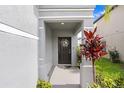 Inviting front porch featuring a decorative wreath on the front door and colorful landscaping at 36312 Garden Wall Way, Zephyrhills, FL 33541