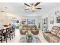 Open concept living room with comfortable seating, a ceiling fan, and access to the dining area at 36312 Garden Wall Way, Zephyrhills, FL 33541
