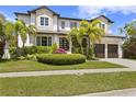 Beautiful two-story home with manicured landscaping and a brick driveway with palm trees at 4807 W Longfellow Ave, Tampa, FL 33629
