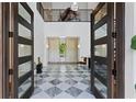 Elegant foyer with soaring ceilings, checkered marble floors, and grand entry doors at 4807 W Longfellow Ave, Tampa, FL 33629