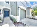 Attached garage and covered entrance with modern blue door and manicured landscaping at 4910 Chatham Gate Dr, Riverview, FL 33578