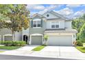 Inviting two-story townhome with a two-car garage and lush green landscaping at 4910 Chatham Gate Dr, Riverview, FL 33578