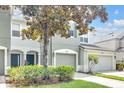 Two-story townhome featuring a two-car garage, covered entry, and mature tree at 4910 Chatham Gate Dr, Riverview, FL 33578