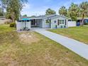 Charming single-story home featuring well-maintained landscaping, a long driveway, and cozy front porch at 512 Flame Tree Dr, Apollo Beach, FL 33572