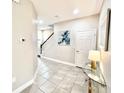 Welcoming foyer with tile floors, a staircase, modern decor, and ample natural light at 6118 Voyagers Pl, Apollo Beach, FL 33572