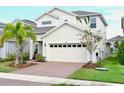 Lovely two-story home showcases a brick driveway, a two-car garage, and manicured landscaping at 6118 Voyagers Pl, Apollo Beach, FL 33572
