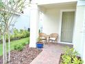 Inviting front porch with a cozy seating area, lush landscaping, and a charming entrance at 6118 Voyagers Pl, Apollo Beach, FL 33572