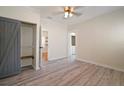 Bright bedroom featuring wood-look flooring, barn door closet, and ensuite access at 6419 S Englewood Ave, Tampa, FL 33611