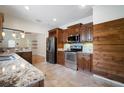 Well-equipped kitchen with stainless steel appliances, granite countertops, and dark wood cabinets at 6419 S Englewood Ave, Tampa, FL 33611