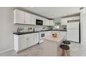 White kitchen featuring modern appliances, ample cabinet space, and a central island with seating at 6604 2Nd Ne Ave, Bradenton, FL 34208