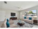 Bright living room with neutral tones, tile floors, and plenty of natural light from the sliding glass door at 6604 2Nd Ne Ave, Bradenton, FL 34208