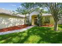 Attractive home with verdant lawn, mature landscaping, and a cozy front entrance with a covered porch at 6918 Potomac Cir, Riverview, FL 33578