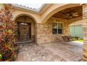Inviting covered front porch with stone accents, brick pavers, and a charming swing at 6928 Cozumel Ct, Land O Lakes, FL 34637