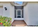 Inviting front porch with brick pavers, colorful flowers, and a secure screen door at 746 Masterpiece Dr, Sun City Center, FL 33573