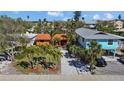 Charming single-story home with red tile roof, surrounded by lush landscaping and mature palm trees at 819 Gulf Blvd, Indian Rocks Beach, FL 33785
